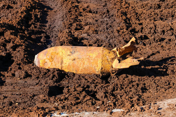 Ржавая мировая война реликтовая бомба, обнаруженная в грязной почве, интенсивная атмосфера, крупный план, исторический артефакт военного времени на бесплодном поле, горизонтальное