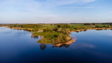 Sakin mavi sularla çevrili sakin bir ada. Barışçıl yeşil bir adanın havadan görünüşü, sakin bir ruh hali, yüksek açılı çekim, kırsal yerleşim, doğa anlayışı ve rahatlama..