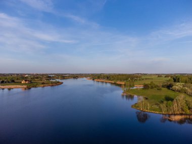 Sakin mavi sularla çevrili sakin bir ada. Barışçıl yeşil bir adanın havadan görünüşü, sakin bir ruh hali, yüksek açılı çekim, kırsal yerleşim, doğa anlayışı ve rahatlama..