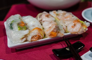 Taze Vietnam karidesli börek ve siyah tabakta fıstık sosu. Yakın çekim, canlı renkler, zarif kaplama, Asya mutfağı, restoran dekorasyonu, iyi yemek, iştah açıcı ruh hali, aşçılık ayrıntıları..