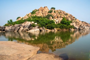 Tungabhadra Nehri 'ndeki tepelerin yansıması Hampi, Karnataka