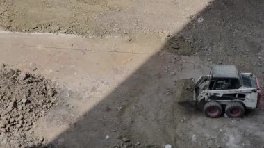 Mini hidrolik kızak dümen yükleyicisi inşaat alanındaki toprağı hissediyor