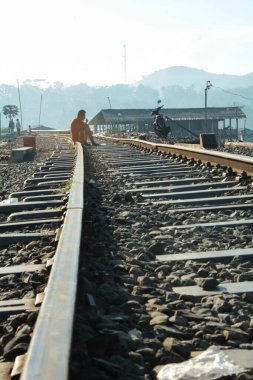 Ambarawa, Central Java, Endonezya - 11 Mayıs 2018: Yaşlı bir adam 11 Mayıs 2018 'de Endonezya' da Ambarawa, Central Java, Endonezya 'da turizm demiryolunun raylarında oturur..