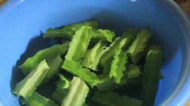 Kecipir meyvesi, aynı zamanda Psophocarpus tetragonolobus olarak da bilinir, mavi bir kabın içinde kaynatılmaya ve ev yapımı basit bir yemek haline getirilmeye hazırdır..