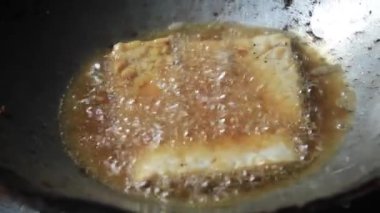 Tempeh kızartma tavasında kızgın yağla kızartılıyor