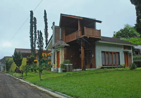 stock image There stands a 2-storey villa house in Tawangmangu overlooking a black sand village road.