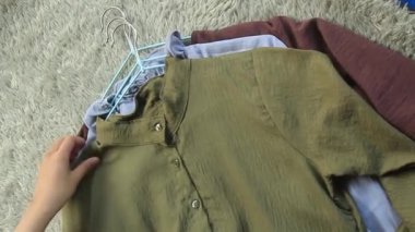 Askılara bağlanmış desenli kadın bluzları tek tek kontrol edildi..