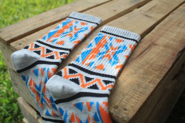 Tahta bir kutunun üzerinde çeşitli desenleri olan bir çift çorap.