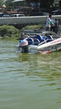 Yogyakarta, Endonezya - 21 Temmuz 2024: Rıhtımdan, bir tur operatörüne ait bir sürat teknesi, Rowo Jombor Gölü, Yogyakarta manzarası için ziyaretçiler tarafından kiralanır..