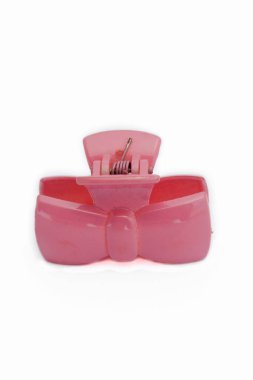 Beyaz arkaplanda izole edilmiş kurdele şeklinde pembe plastik pençe saç tokası.