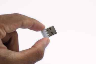 Beyaz bir arkaplanda küçük bir USB flaş bellek var.