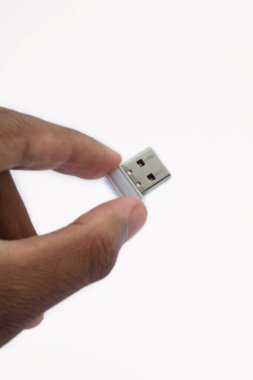 Beyaz bir arkaplanda küçük bir USB flaş bellek var.