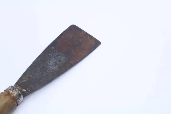 Beyaz arka planda tahta saplı paslı, eski bir macun bıçağının yakın çekim görüntüsü