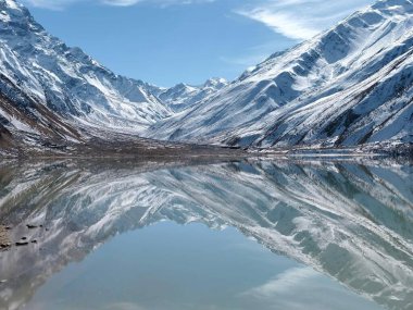 Güneşli bir günde parlak mavi bir gökyüzünün altında karla kaplı dağ sıraları.