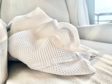 Kanepedeki temiz, beyaz kumaşın yakın görüntüsü.