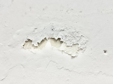 Beyaz arkaplan duvarındaki çatlak ve soyulmuş doku