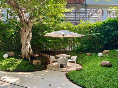 Gölgeli, taze ve güzel bir bahçe atmosferi olan açık hava yemek alanı.