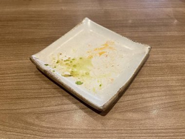 Ahşap masadaki kirli ve lekeli beyaz kare plakayı kapat.