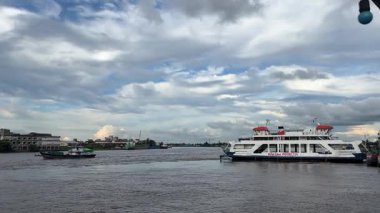 Feribot, yerel sürat teknesi ve Kapuas Nehri 'ndeki mavna arasında hareketlilik görünüyor.