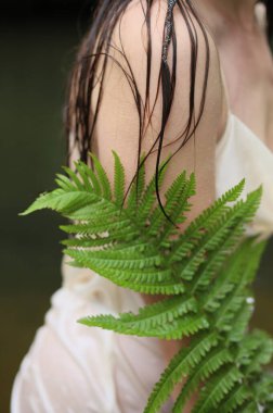 Eğreltiotu, genç bir kızın çıplak omzunu güzelce örter.