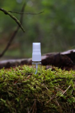 Yaprakların arasındaki bir taşın üzerinde beyaz bir kozmetik tüpü. Doğal bitki kozmetik konsepti. Modelleme. Bulanık arkaplan.