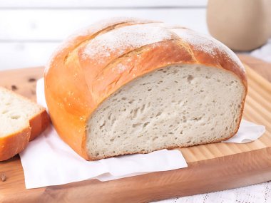 Arka planda ekmek sepeti olan bir somun ekmek kesim tahtasının üzerinde. 