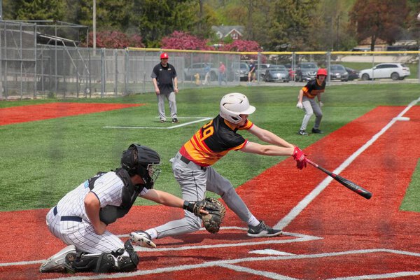 школьный бейсболист, качающийся на противном слайдере