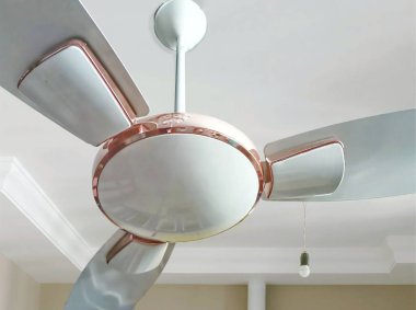 Metalik altın aksanlı modern tavan vantilatörü, gösterişli tasarlanmış üç pervanesi var..