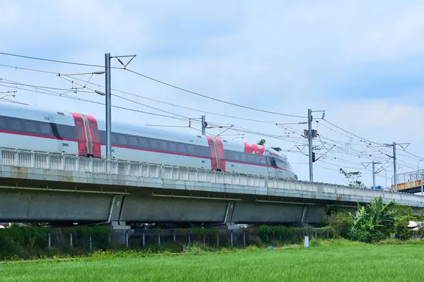 Yüksek hızlı Whoosh treni Endonezya 'nın kırsal kesimlerindeki yüksek raylarda süzülüyor, yemyeşil bir arazi ve mavi gökyüzüne karşı modern ulaşımı sergiliyor..