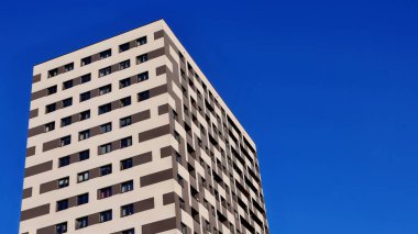Açık mavi gökyüzüne karşı apartman binası. Gökyüzüne karşı çok katlı grafiksel gökdelen.
