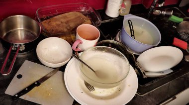 A kitchen sink filled with dirty dishes and utensils, waiting to be cleaned. A kitchen sink filled with dirty dishes and utensils, waiting to be cleaned. clipart