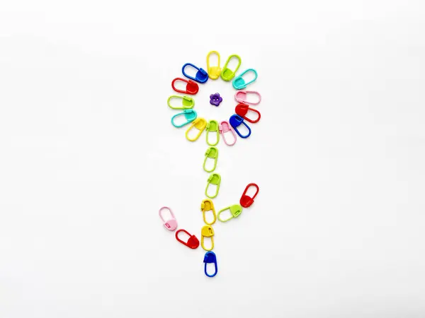 Düğme merkezli bir çiçeğe yerleştirilmiş örgü işaretleyiciler