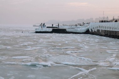 Gün doğumunda karla kaplı Karadeniz kıyıları. Şimdi, buz, donmuş su. Yumuşak güneş ışığı. Resimli kış manzarası. Mevsimler, doğa, çevre, iklim değişikliği, küresel ısınma temaları