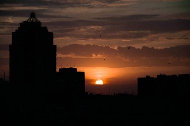 Odesa 'nın merkezindeki modern ofis binalarının üzerinde gün doğumu. Gökyüzü manzarası, güneş ışığı ve parlak bir ışık tonu. İnşaat işi konsepti. Yüksek kalite fotoğraf