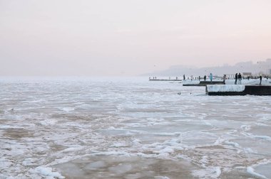 Gün doğumunda karla kaplı Karadeniz kıyıları. Şimdi, buz, donmuş su. Yumuşak güneş ışığı. Resimli kış manzarası. Mevsimler, doğa, çevre, iklim değişikliği, küresel ısınma temaları