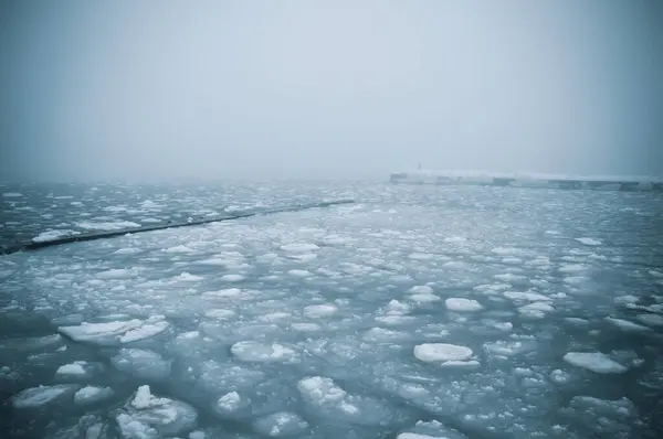 stock image Snow-covered Black sea shore at sunrise.Snow, ice, frozen water. Soft sunlight. Picturesque winter scenery. Seasons, nature, environment, climate change, global warming themes