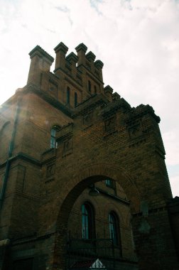 Chernivtsi Ulusal Üniversitesi, Ukrayna 'nın Chernivtsi şehrinde Bukovinian ve Dalmaçyalı Metropolitanların evi. Güneşli bir günde yeşil ağaçlar ve çalılarla kaplı kırmızı tuğla cephe. Yüksek kalite fotoğraf