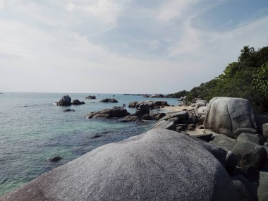 Endonezya 'daki Bangka-Belitung Adası' nda sakin ve temiz bir sahil. Büyük granit kayalar, yeşil ağaçlar ve beyaz kumlar tatilinizin tadını çıkarmak için çok güzel..