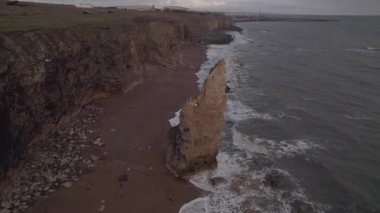 Drone fırtınalı bir kış gününde Seaham 'da, Chemical Beach' te kaya yığınlarının etrafında uçar.