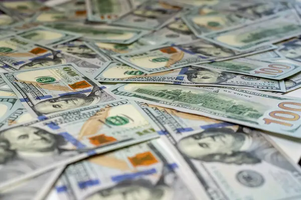 Yüz dolarlık banknotlar birbirine yakın bir şekilde dizilmiş, yeni para biriminin karmaşık tasarımı ve parlak renklerini gösteriyor, desenlerini ve dokusunu vurguluyor, yakın plan, arka plan, yan görüş