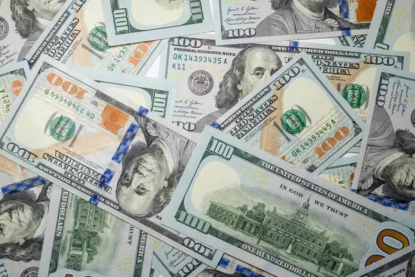 Yüz dolarlık banknotlar birbirine yakın bir şekilde diziliyor, yeni para biriminin karmaşık tasarımı ve parlak renklerini gösteriyor, desenlerini ve dokusunu vurguluyor, yakın plan, arka plan