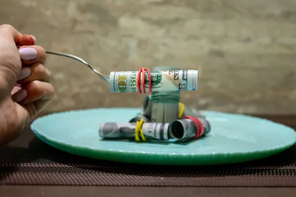 Para turkuaz bir tabağa saçılmış, yanında çatal ve bıçak var, yemek masrafları, fiyat artışı....