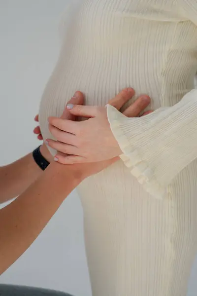 Anne ve baba hamile karnına sarılıyorlar.