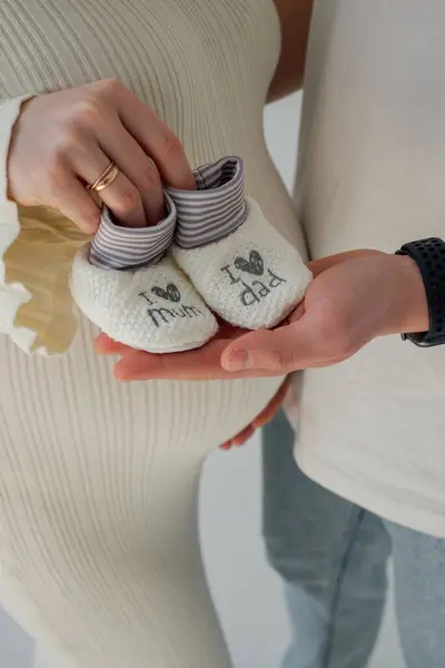 Çocuk bekleyen genç bir çift, 8 aylık bebek çorapları.