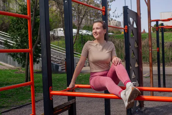 Kız bir atlet, parkta antrenmandan sonra dinleniyor. Kendine ve sağlığına dikkat ediyor..