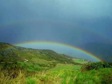 Paisaje de la luz del arco iris en las praderas tras la lluvia clipart