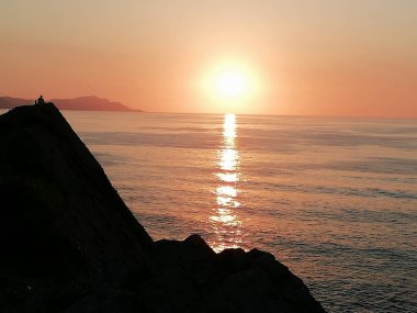 Atardecer sereno en las rocas y arena de la playa