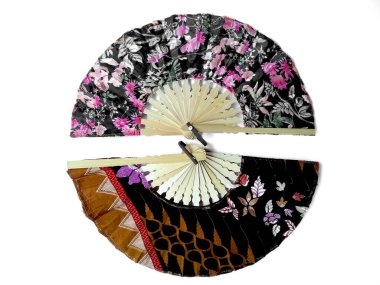 Kipas Tangan Motif Batik veya el yelpazesi Batik bambu ve batik kumaştan yapılmıştır. Batik desenli el vantilatörü beyaz arka planda izole edilmiş. Bali Endonezya 'dan el yelpazesi