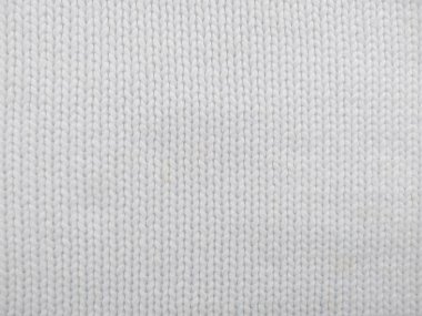 Yün ipliğinden örülmüş giysiler. İplik çerçevesi için yün iplik arkaplanı. El sanatları geçmişi için beyaz örgü ipliği