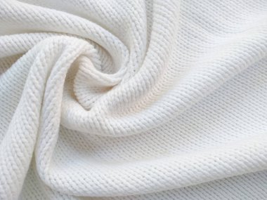 Yün ipliğinden örülmüş giysiler. İplik çerçevesi için yün iplik arkaplanı. El sanatları geçmişi için beyaz örgü ipliği